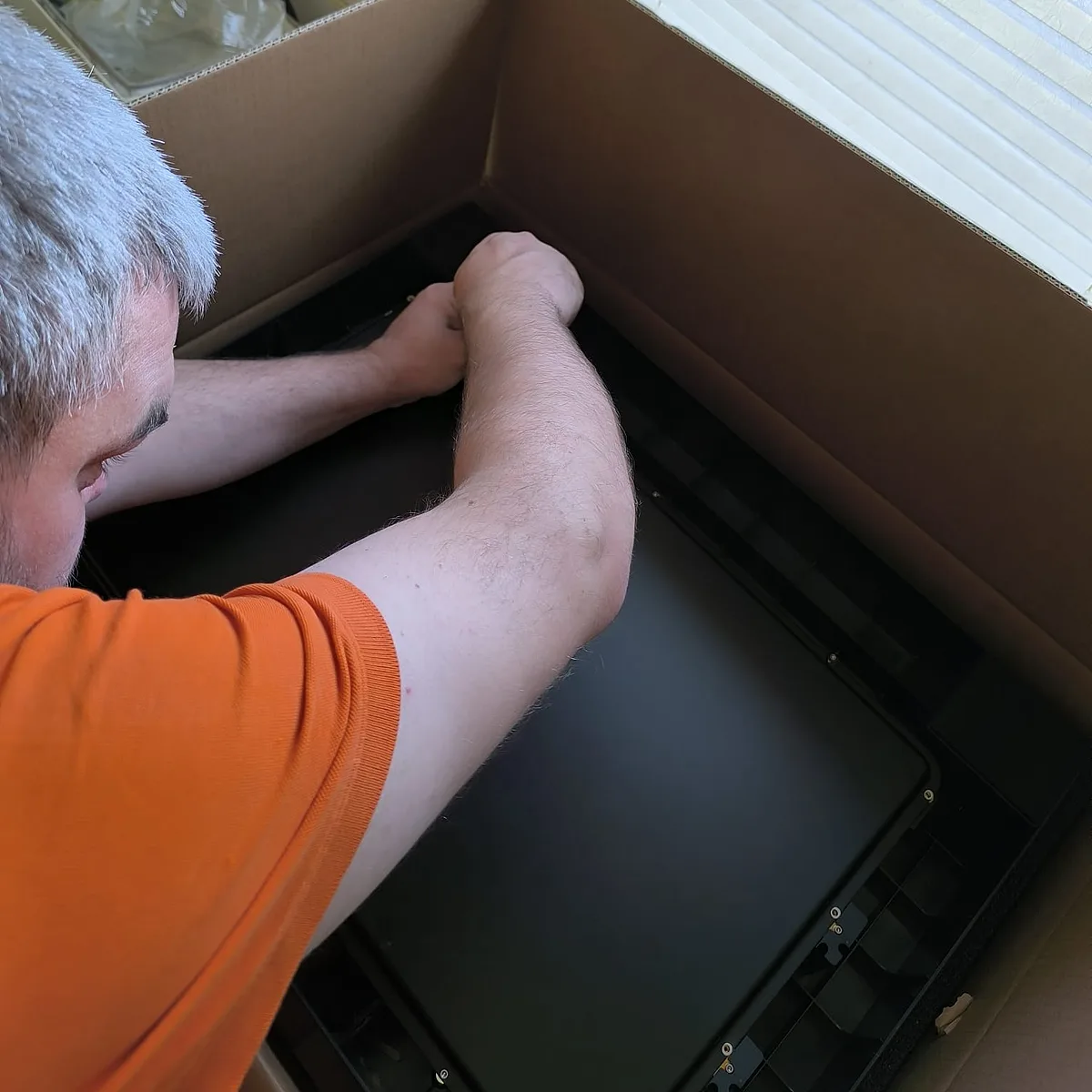 Der xTool S1 wird aus dem Versandkarton gehoben